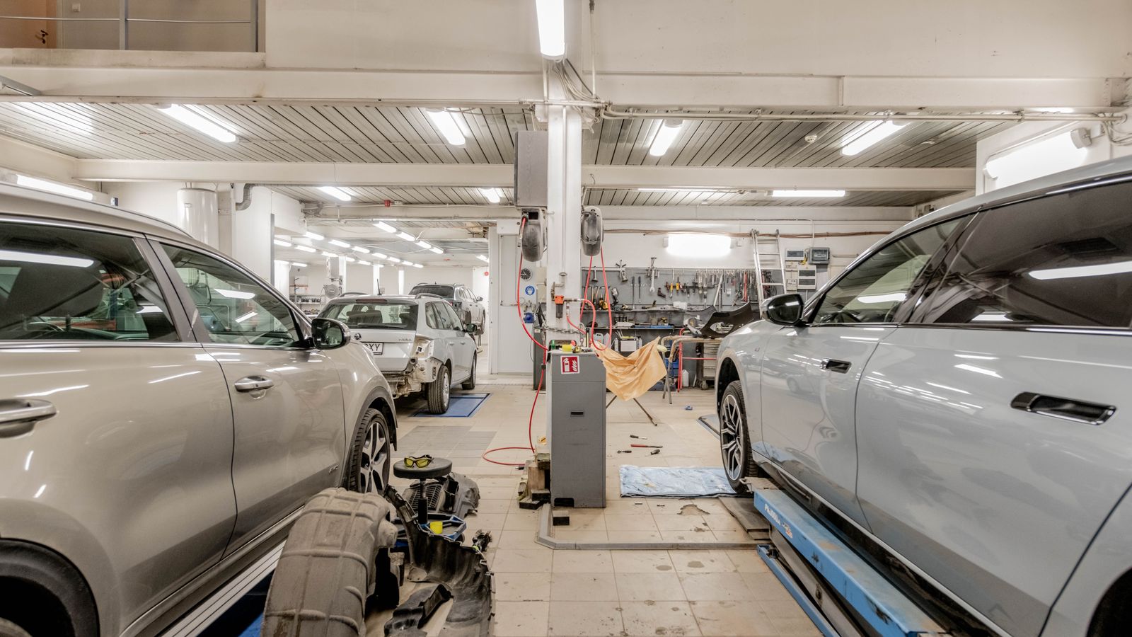 Cars on lifts in a bright auto repair workshop